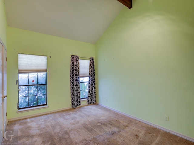 carpeted spare room featuring beamed ceiling and high vaulted ceiling