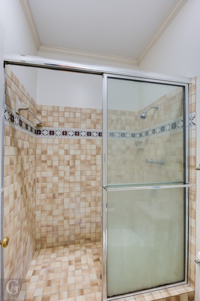 bathroom featuring a shower with shower door and crown molding