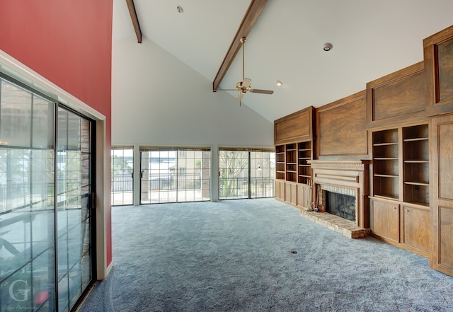 unfurnished living room with ceiling fan, beam ceiling, carpet, high vaulted ceiling, and a fireplace