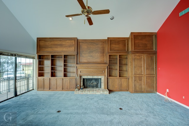 unfurnished living room with carpet floors, a tiled fireplace, high vaulted ceiling, and ceiling fan