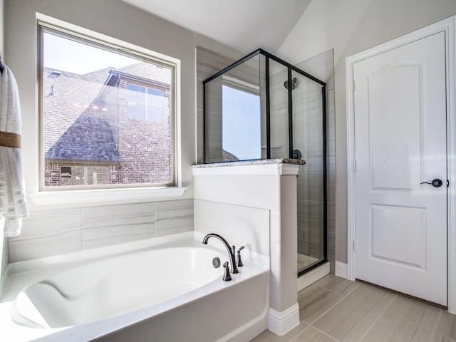 bathroom featuring lofted ceiling and shower with separate bathtub