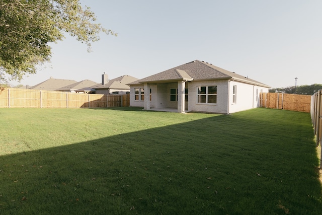 rear view of property with a lawn and a patio