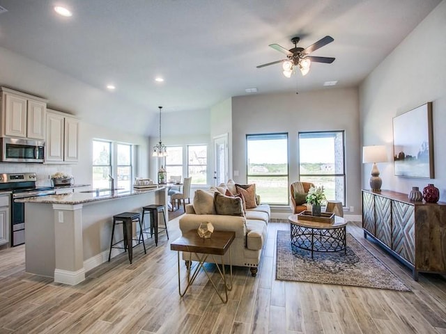 living room with sink and ceiling fan with notable chandelier