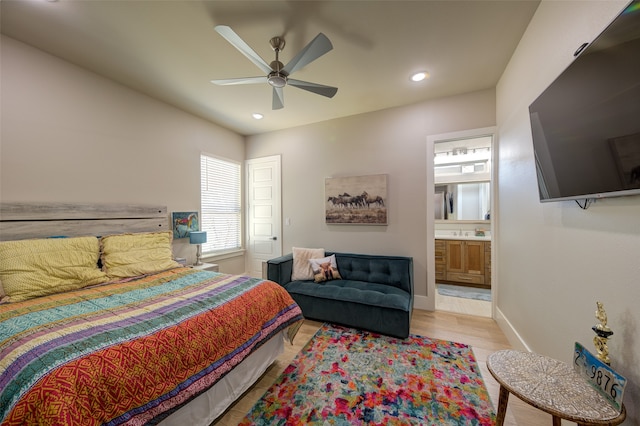 bedroom with ceiling fan, light hardwood / wood-style flooring, and ensuite bath