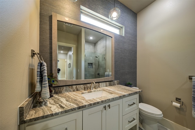 bathroom with an enclosed shower, vanity, and toilet