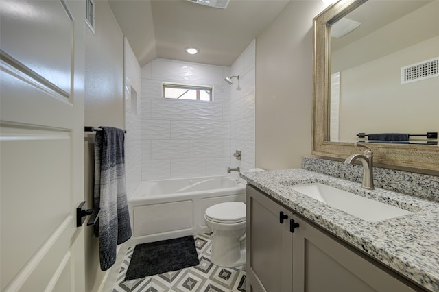 full bathroom featuring tile patterned flooring, toilet, tiled shower / bath combo, and vanity