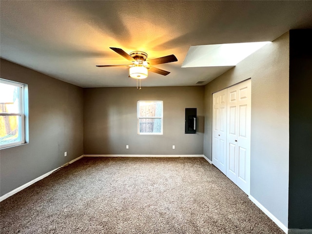 empty room with carpet flooring, ceiling fan, and a healthy amount of sunlight