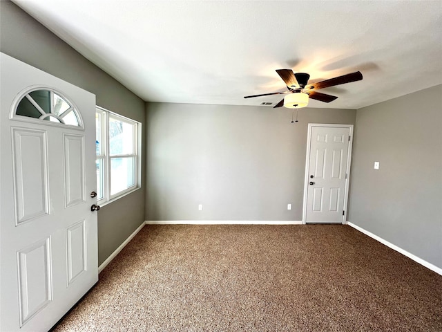 foyer with ceiling fan and light carpet