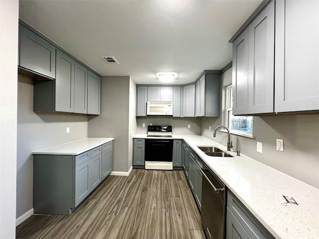 kitchen featuring sink, gray cabinetry, dark hardwood / wood-style floors, and white appliances