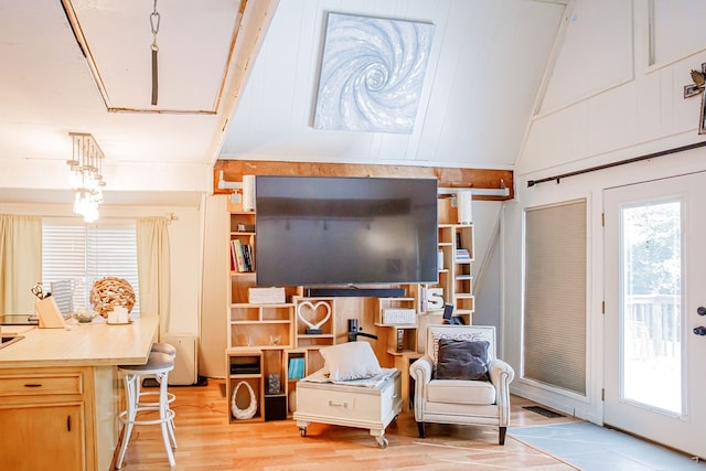 living area with vaulted ceiling and light wood-type flooring