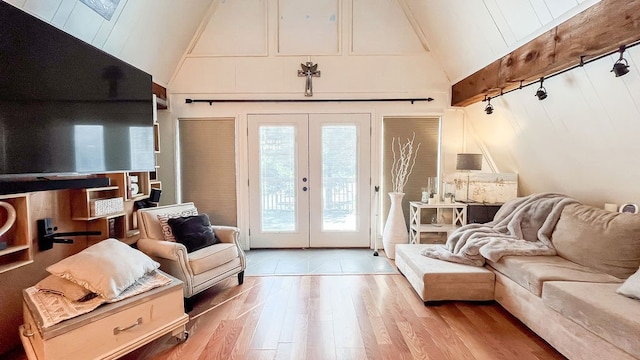 interior space featuring lofted ceiling with skylight, light hardwood / wood-style floors, and french doors