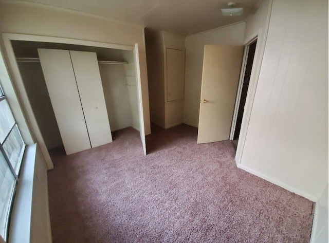 unfurnished bedroom featuring light carpet and a closet