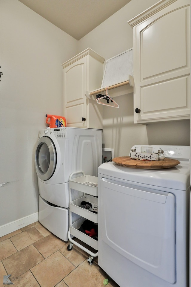 washroom with light tile patterned floors, separate washer and dryer, and cabinets