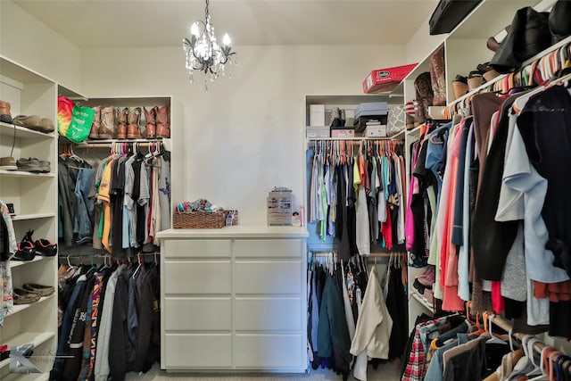 spacious closet featuring a notable chandelier and carpet