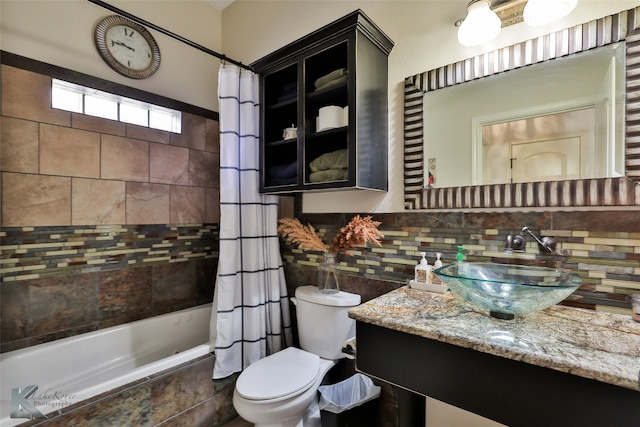 full bathroom with shower / tub combo with curtain, toilet, vanity, and tasteful backsplash