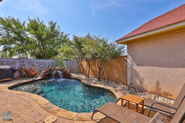 view of swimming pool with pool water feature and a patio area