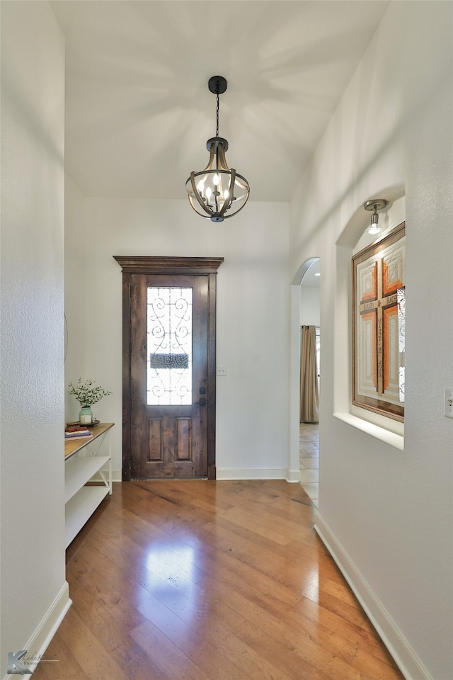 foyer with a notable chandelier and wood-type flooring