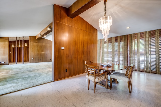 dining room featuring a notable chandelier, wood walls, and lofted ceiling with beams