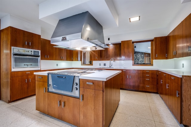 kitchen with island range hood, black oven, sink, and a center island