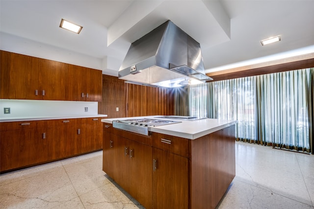 kitchen featuring island range hood, stainless steel gas cooktop, a center island, and light tile patterned floors