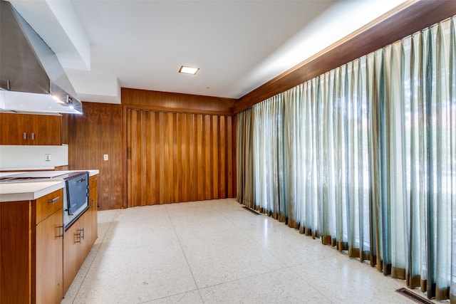 kitchen featuring wood walls and wall chimney exhaust hood