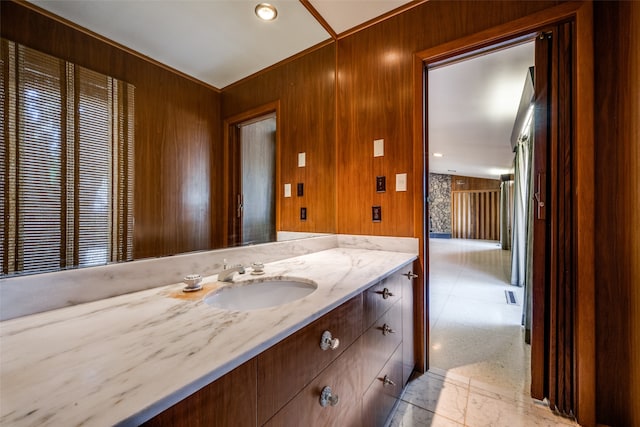 bathroom with wooden walls, vanity, and tile patterned floors