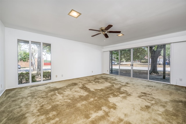 carpeted spare room with ceiling fan