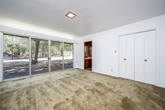 unfurnished bedroom featuring carpet and connected bathroom