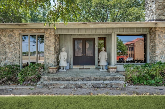 property entrance with stone siding and french doors