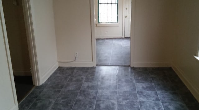 unfurnished room featuring dark tile patterned flooring