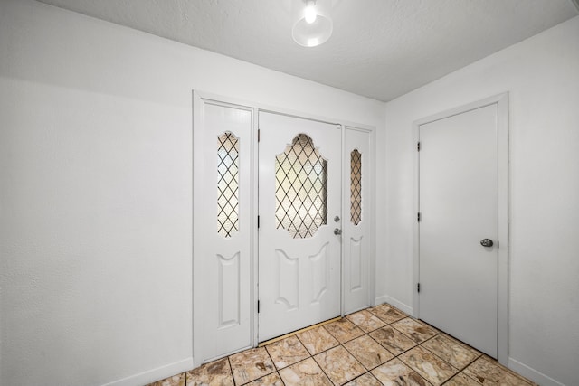 foyer entrance featuring a textured ceiling