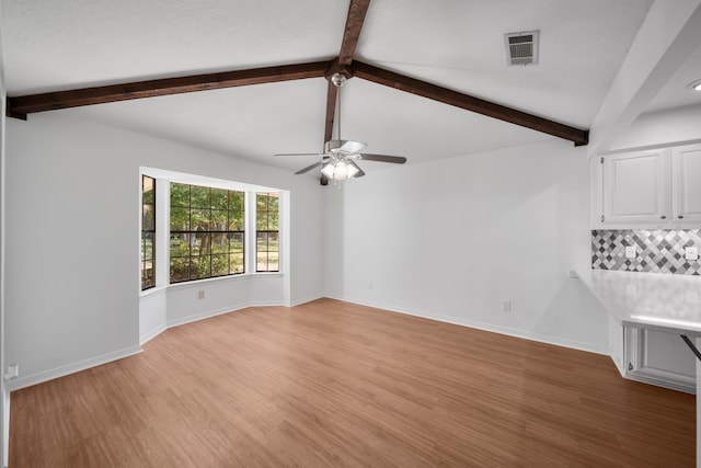 unfurnished living room with lofted ceiling with beams, light hardwood / wood-style flooring, and ceiling fan