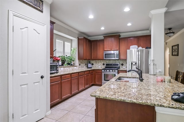 kitchen featuring light tile patterned floors, a sink, appliances with stainless steel finishes, crown molding, and backsplash