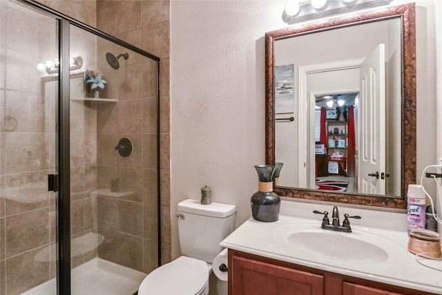 bathroom featuring vanity, toilet, and a stall shower