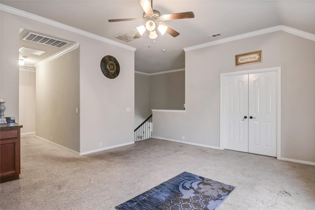 spare room featuring a ceiling fan, crown molding, carpet, and visible vents