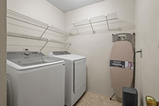 laundry area featuring independent washer and dryer, a textured ceiling, and light tile patterned floors