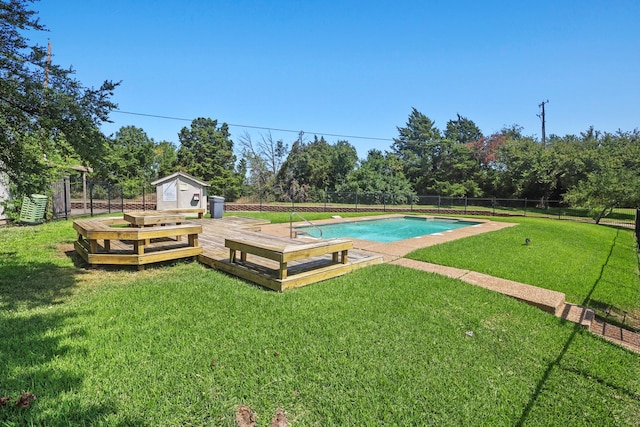 view of pool featuring a wooden deck, a yard, and a storage unit