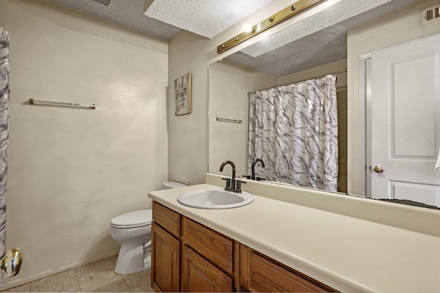 bathroom featuring tile patterned floors, vanity, a textured ceiling, and toilet