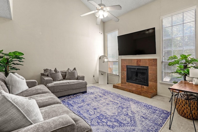 carpeted living room featuring a fireplace, a textured ceiling, vaulted ceiling, and ceiling fan