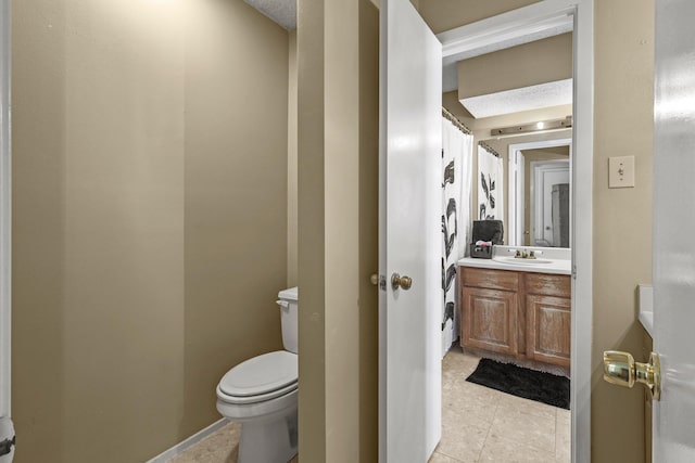 bathroom featuring a textured ceiling, vanity, toilet, and tile patterned floors