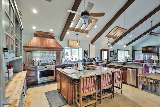 kitchen featuring pendant lighting, appliances with stainless steel finishes, light stone countertops, kitchen peninsula, and a center island