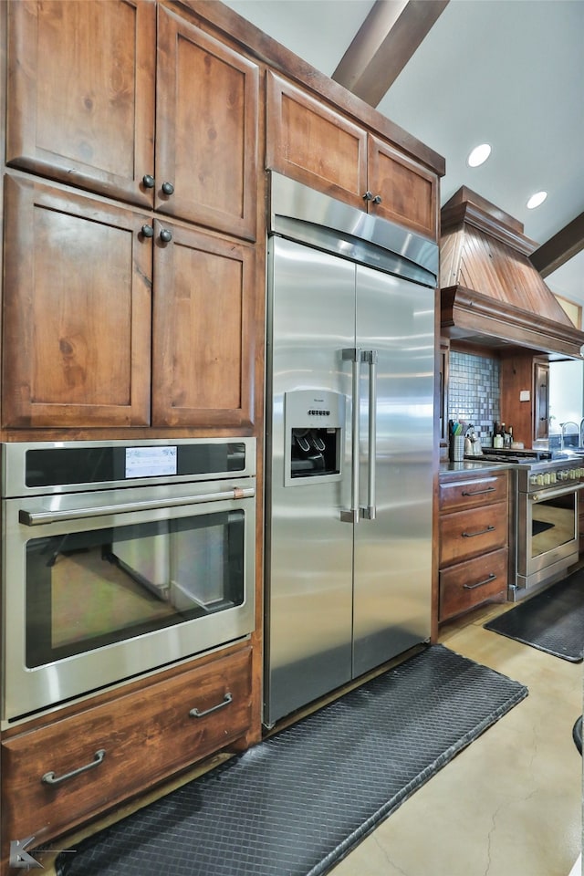 kitchen with tasteful backsplash, premium range hood, and high end appliances