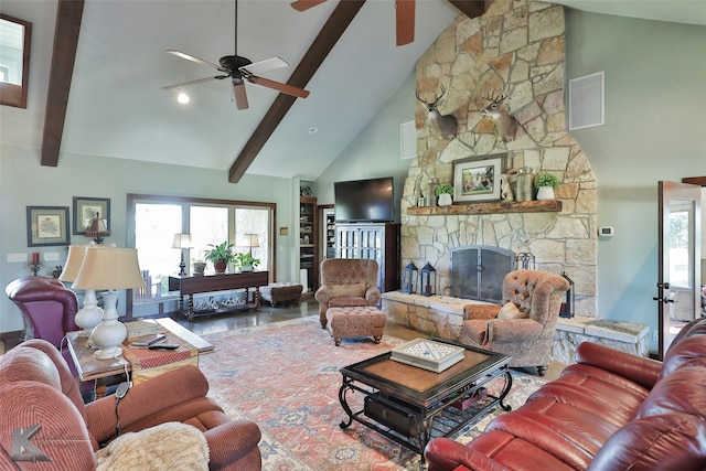 living room featuring hardwood / wood-style floors, high vaulted ceiling, a stone fireplace, beamed ceiling, and ceiling fan