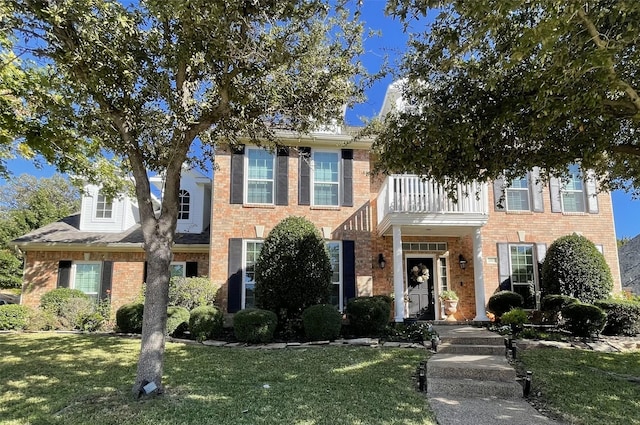 view of front of home featuring a balcony and a front yard