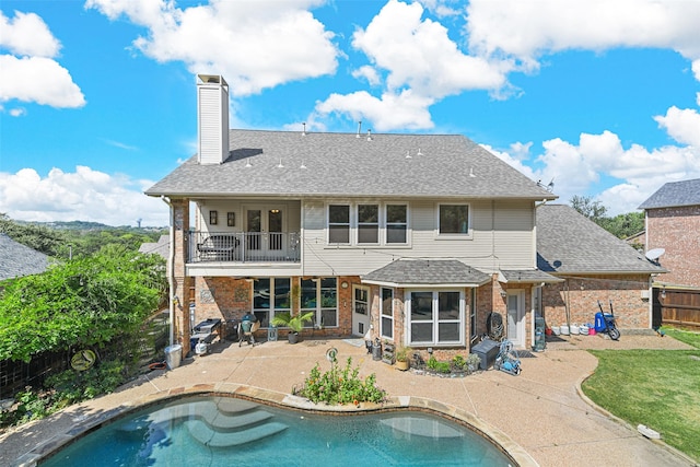 rear view of property with a patio and a balcony