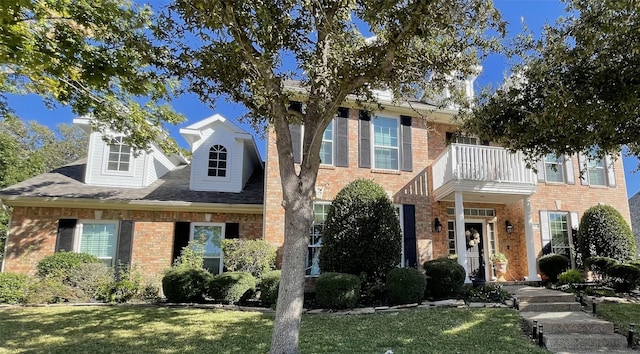 view of front of property with a balcony and a front lawn