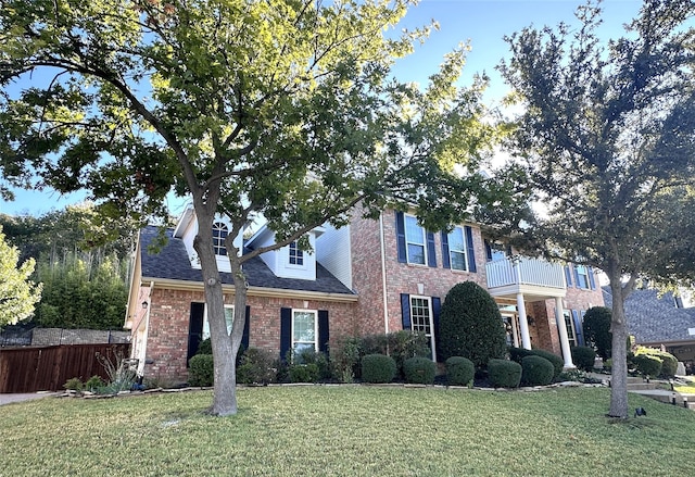 view of front of home with a balcony and a front yard