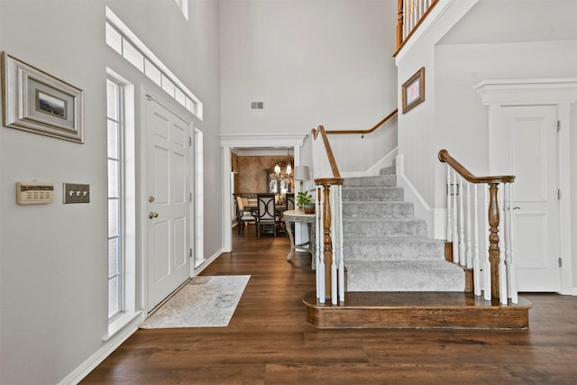 entryway with a towering ceiling and dark hardwood / wood-style floors