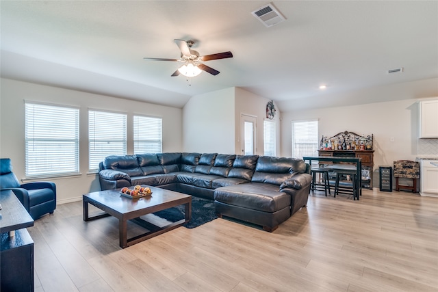 living room featuring ceiling fan, light wood-type flooring, plenty of natural light, and vaulted ceiling