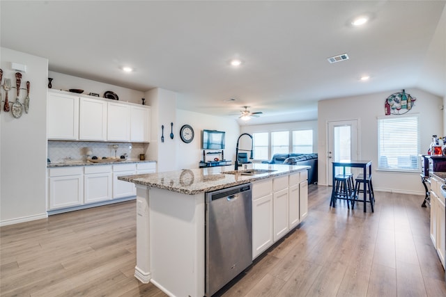 kitchen featuring ceiling fan, light wood-type flooring, white cabinets, dishwasher, and a center island with sink